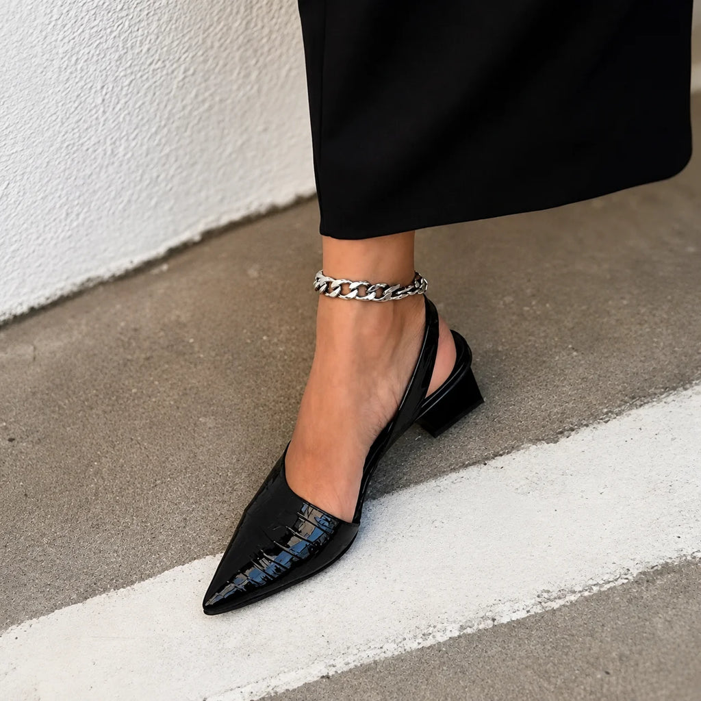 Detail shot of crocodile-embossed upper and elastic slingback feature on women's block heel pumps