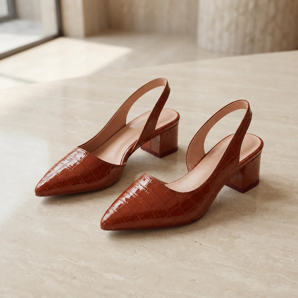 Pair of brown block heel slingbacks displayed at angle highlighting pointed toe and mid-height heel