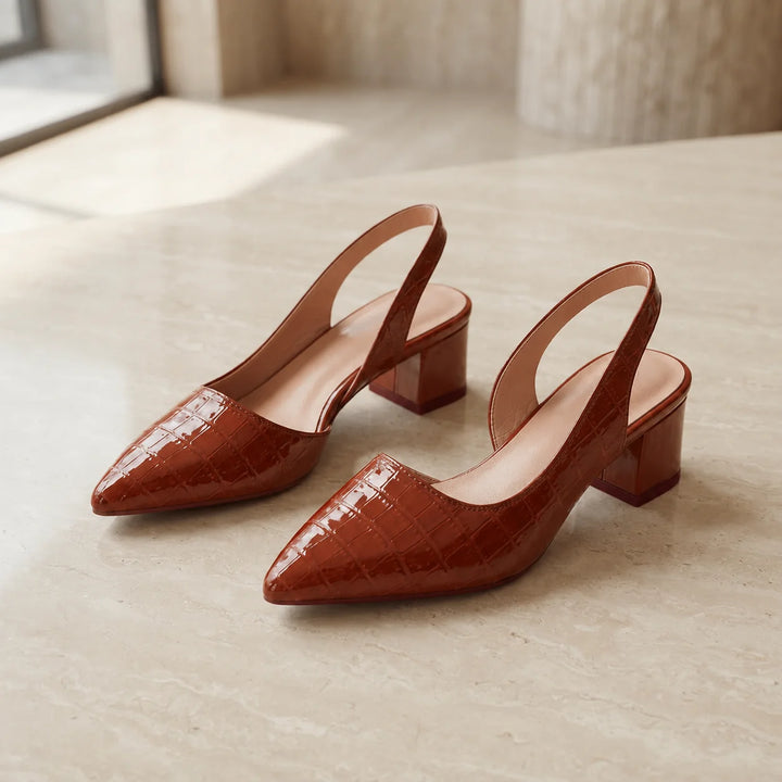 Pair of brown block heel slingbacks displayed at angle highlighting pointed toe and mid-height heel