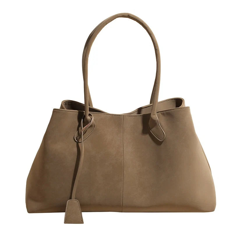 Taupe women's structured tote bag with dual handles and detachable charm on white background