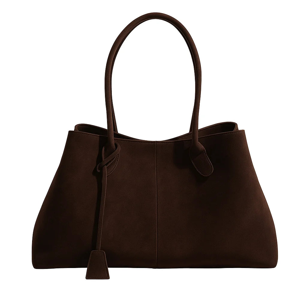 Women's tote bag with detachable charm positioned beside structured base