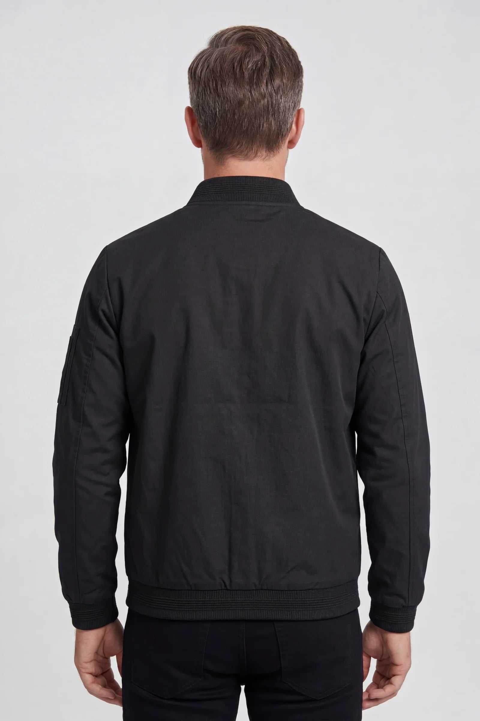 Front view of men's bomber jacket showing streamlined silhouette and sleeve zip pocket detail