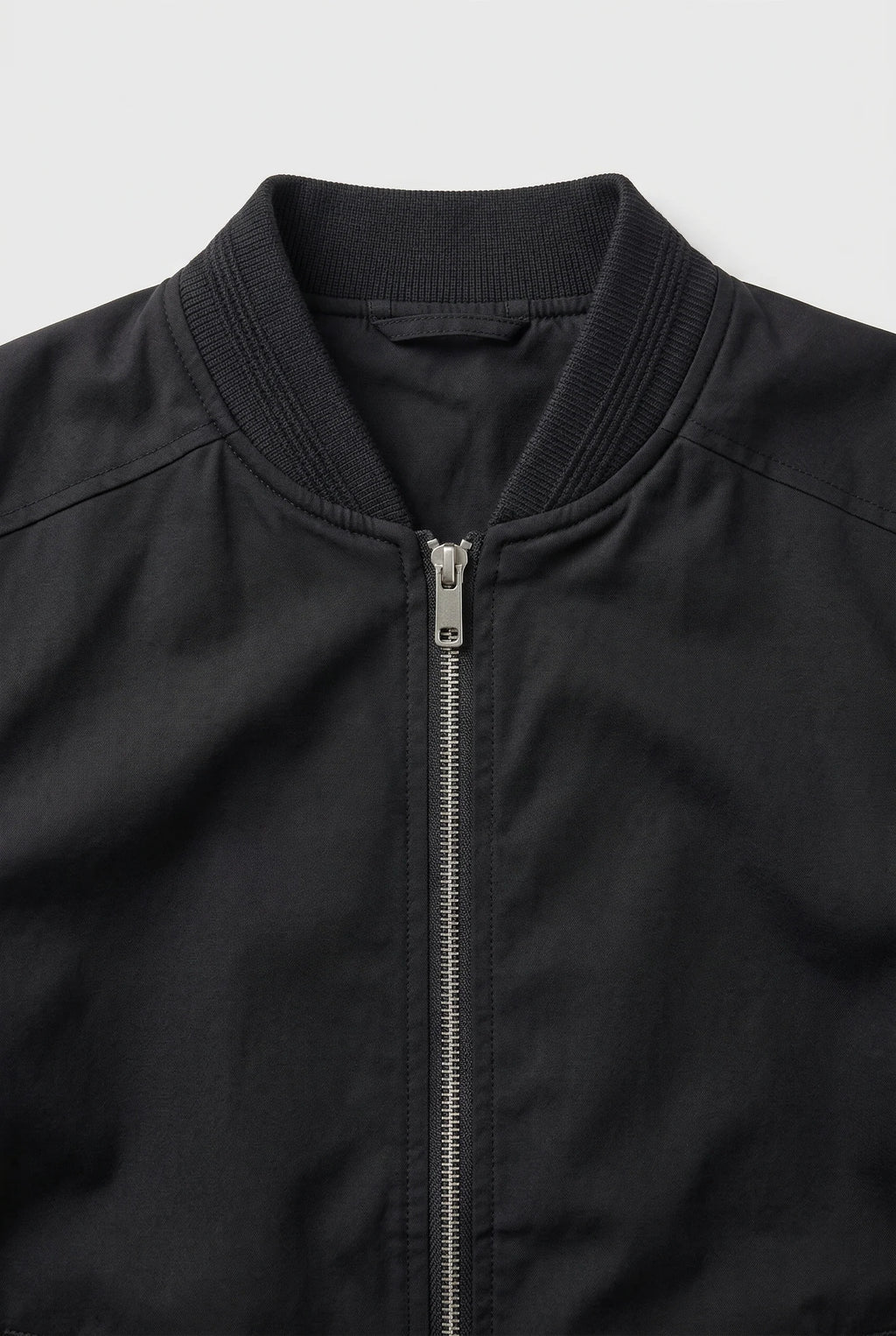 Men's bomber jacket side angle displaying relaxed fit and structured ribbed trims throughout