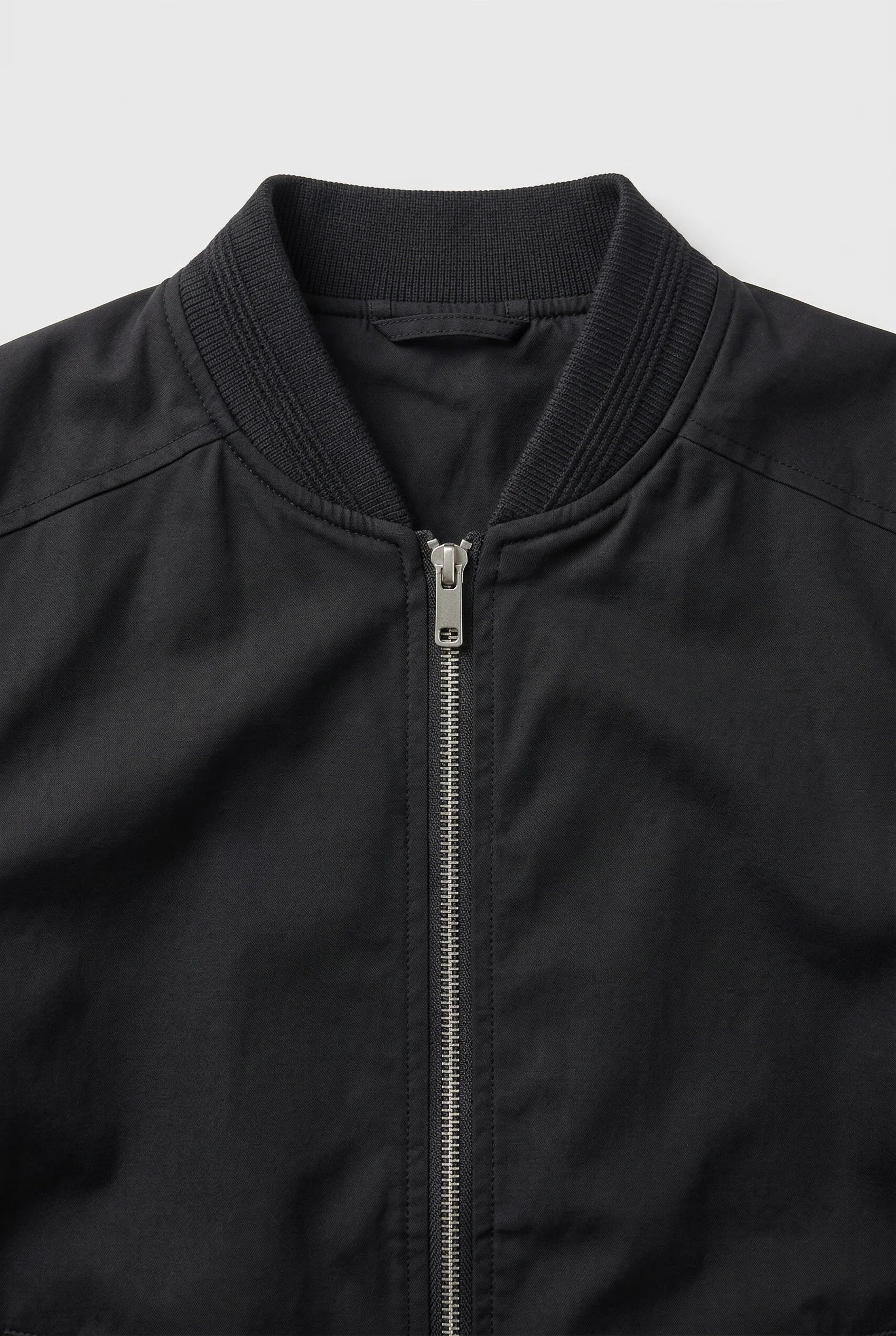 Men's bomber jacket side angle displaying relaxed fit and structured ribbed trims throughout