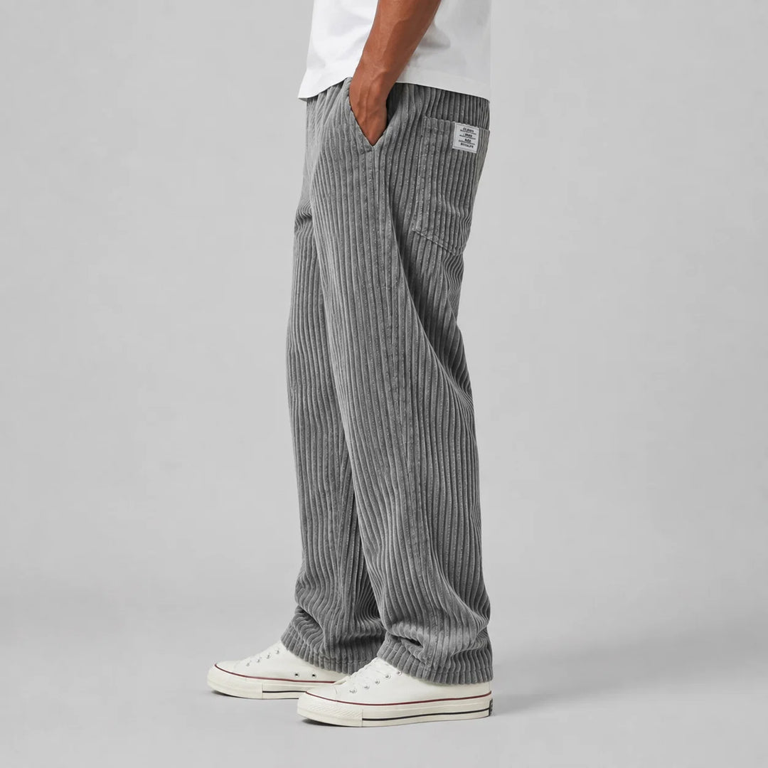 Relaxed fit men's corduroy trousers in grey paired with casual trainers