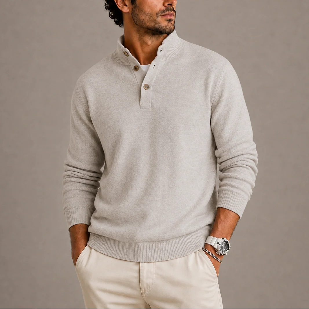 Men's knit polo jumper with button placket and ribbed hem, paired with tailored trousers.