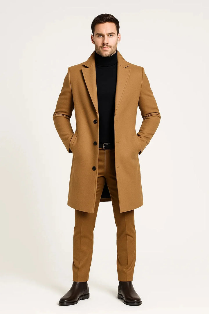 Men's tailored overcoat in camel with notched lapels and single-breasted button closure, styled over black turtleneck and matching trousers