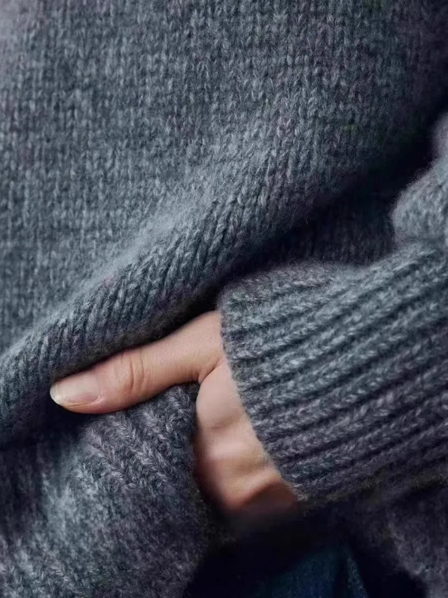 Grey cashmere sweater paired with tailored black trousers for smart-casual styling
