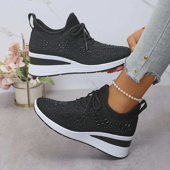 Close-up view of women's trainers showing geometric crystal embellishments across mesh upper