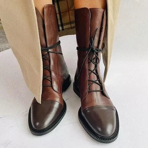 Close-up of women's mid-calf lace-up ankle boots showing front lace closure and chunky rubber sole