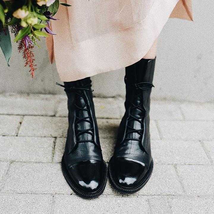 Side view of black textured ankle boots with lace-up detail and structured silhouette