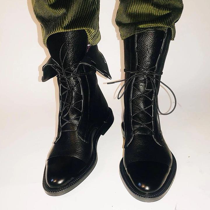 Detail of ankle boot lace closure and smooth glossy toe cap design