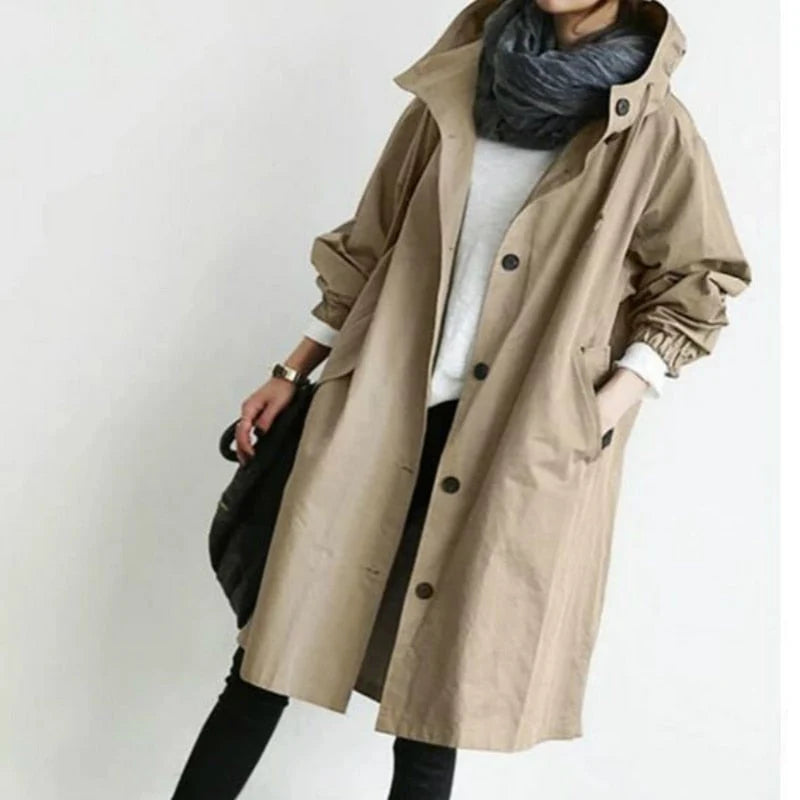 Women's oversized trench coat styled over jumper and black trousers for casual outdoor wear