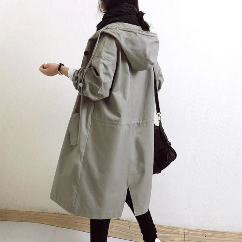 Women's hooded trench coat in light grey paired with scarf for layered autumn look