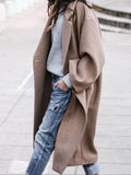 Women's oversized long coat in taupe with wide sleeves and single-breasted closure styled with ribbed jumper