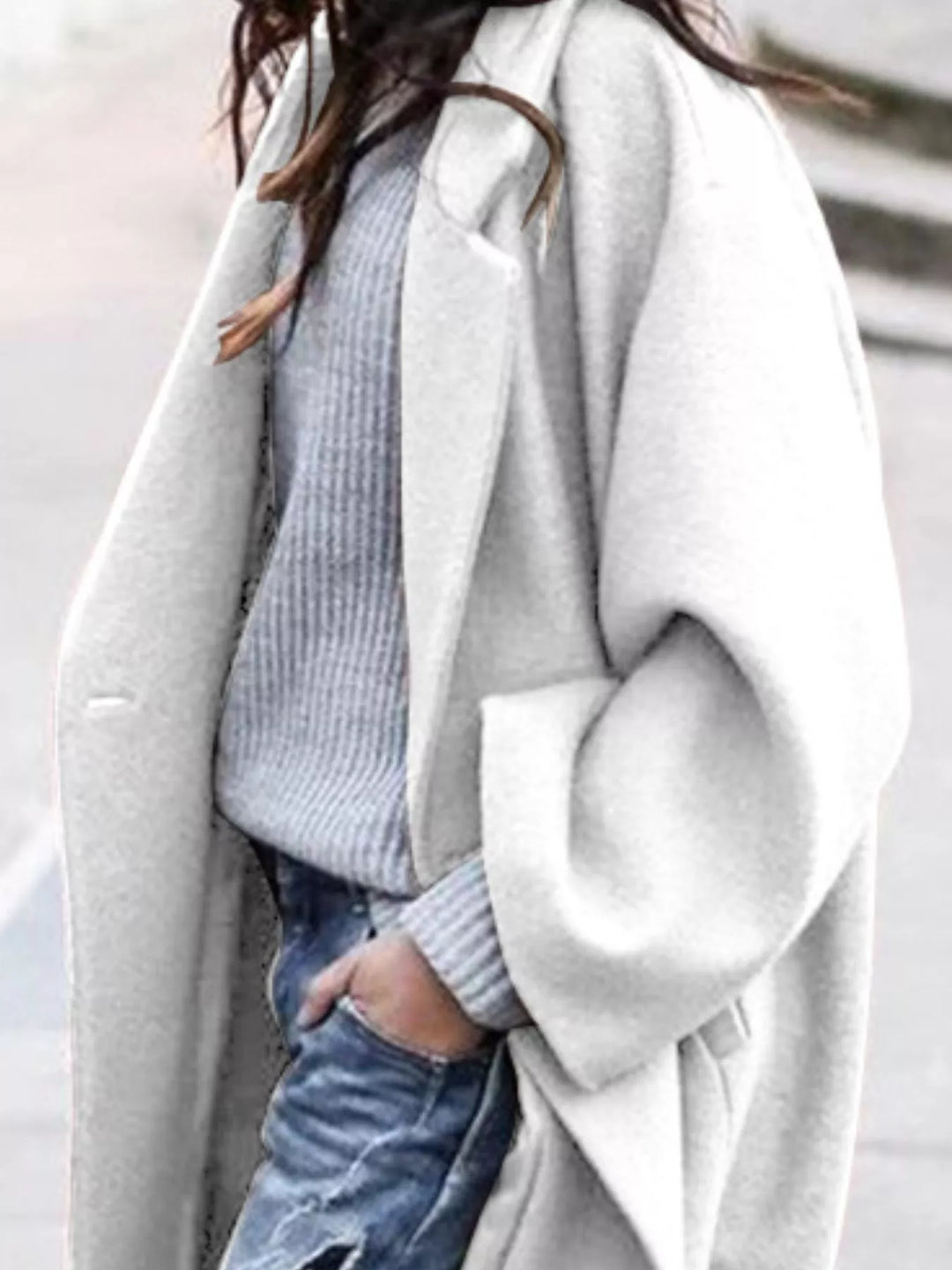 Close-up of women's oversized long coat lapel detail and single-breasted closure with smooth fabric texture