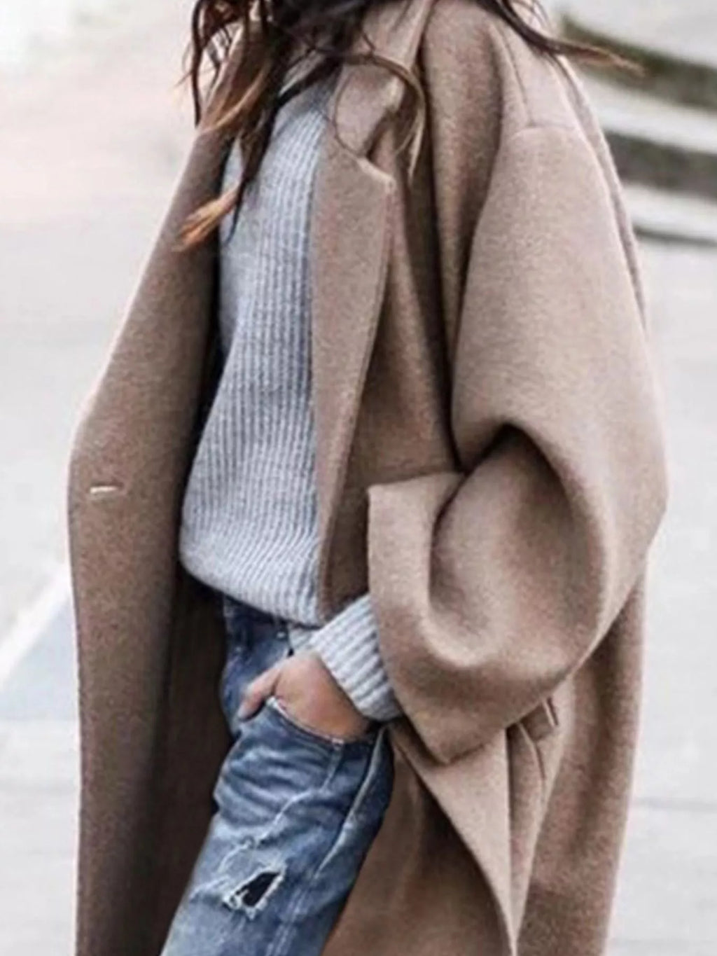 Side view of women's oversized long coat showing relaxed silhouette and knee-length cut with open front