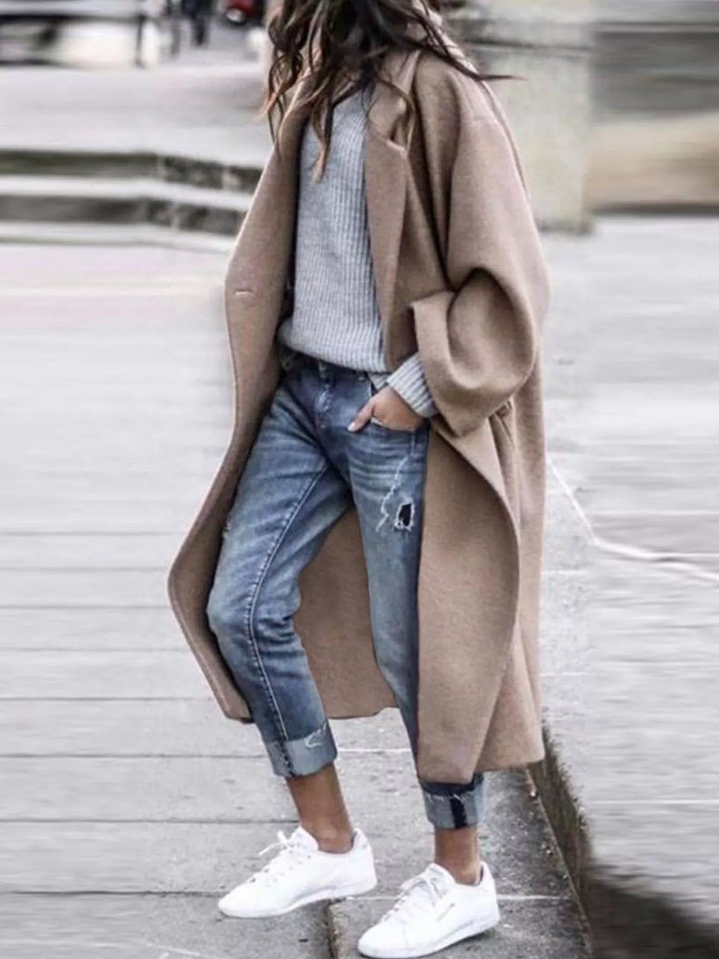 Close-up of women's oversized long coat featuring structured fabric, notch lapels and wide sleeve detail