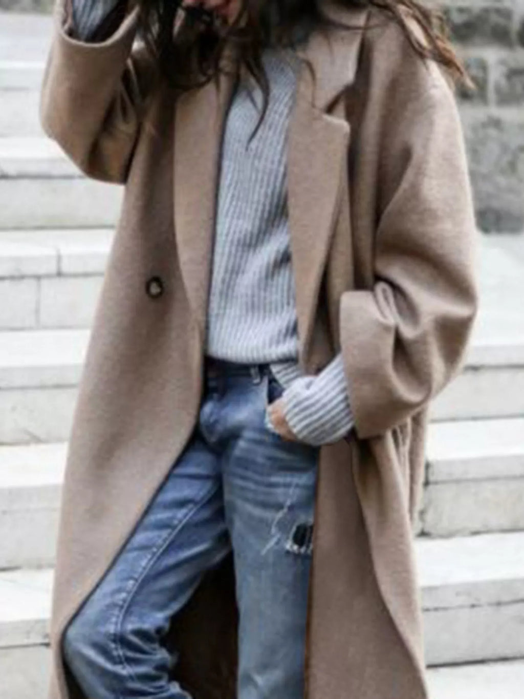 Back view of women's oversized long coat displaying relaxed fit and smooth drape over casual outfit