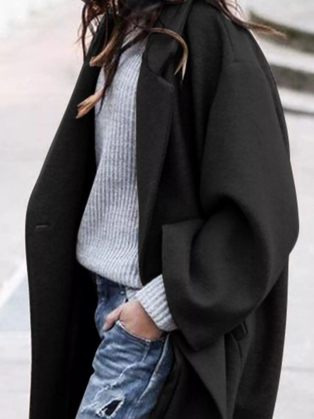 Detail shot of women's oversized long coat showing single-breasted closure and smooth fabric finish