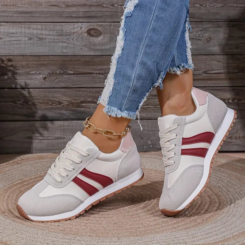 Close-up of lace-up retro trainers showing three-stripe detail and padded collar construction