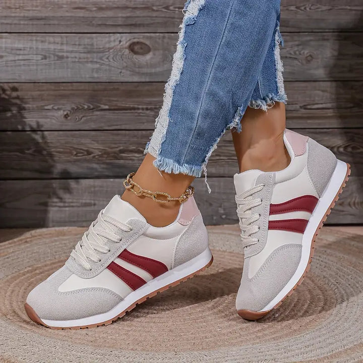 Close-up of lace-up retro trainers showing three-stripe detail and padded collar construction