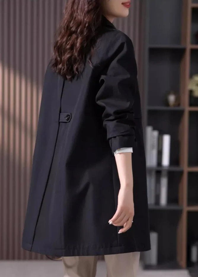 Women's black trench coat with button front and long sleeves styled for smart casual occasions