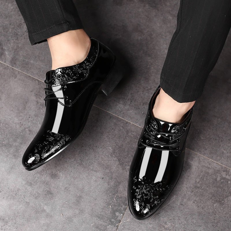 Close-up of embossed swirl pattern on black patent Derby shoes with lace-up closure