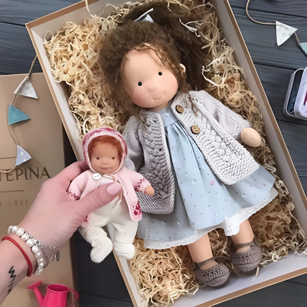 Waldorf doll with pastel-toned dress and cream knit cardigan in presentation box