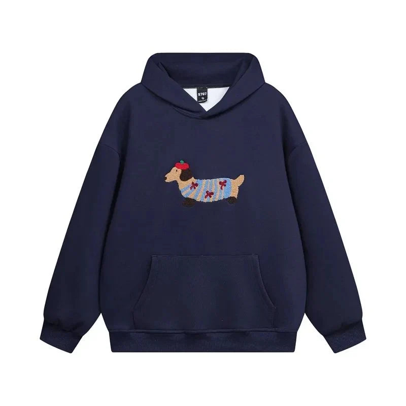 Close-up of embroidered dachshund detail on grey hoodie chest with adjustable drawstring hood