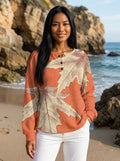 Close-up of oversized leaf print detail on peach long sleeve blouse with smooth fabric texture