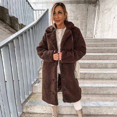 Detail shot of women's teddy coat button closure and soft plush fabric texture
