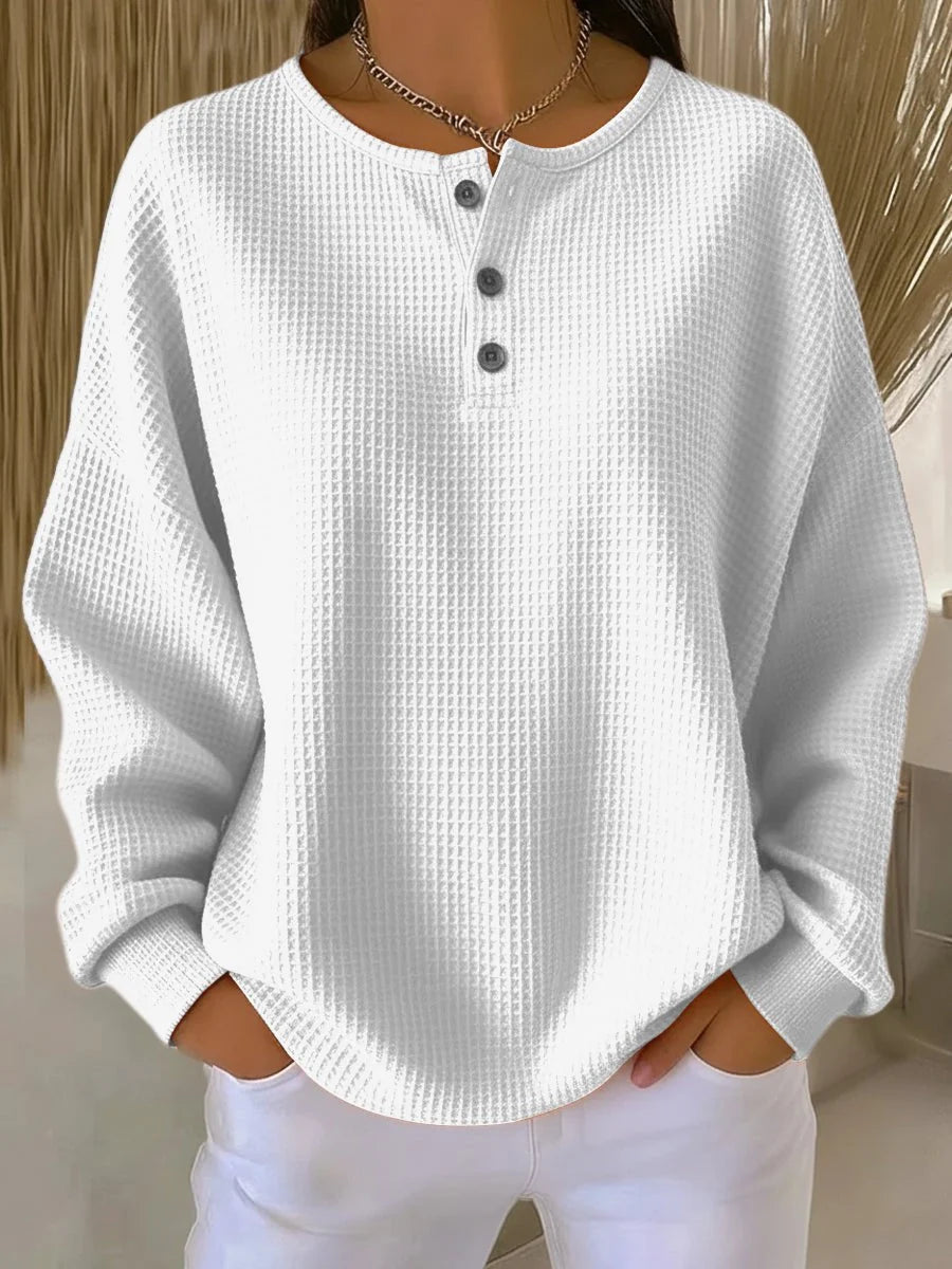 Close-up view of waffle knit henley jumper showing textured fabric and button detail