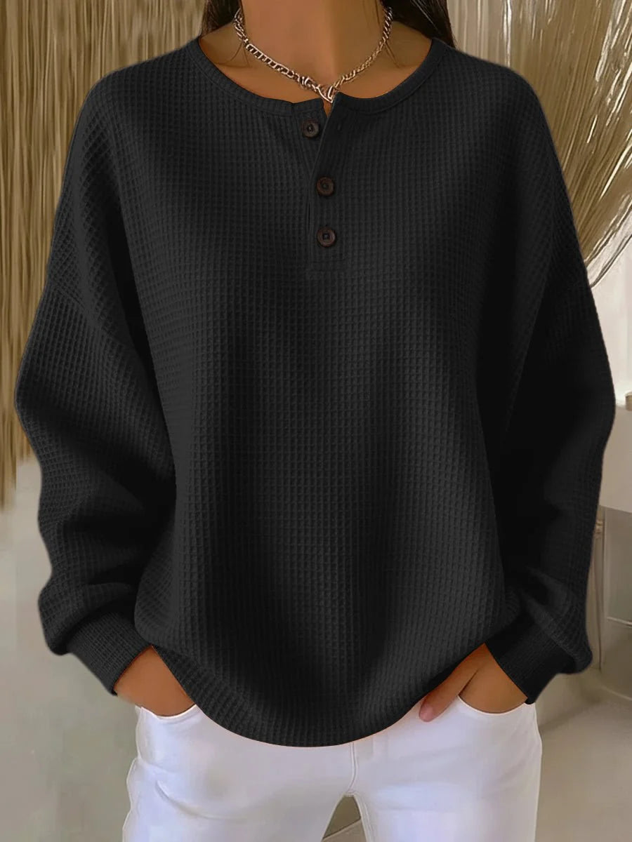 Women's waffle knit henley jumper styled with white trousers for casual wear