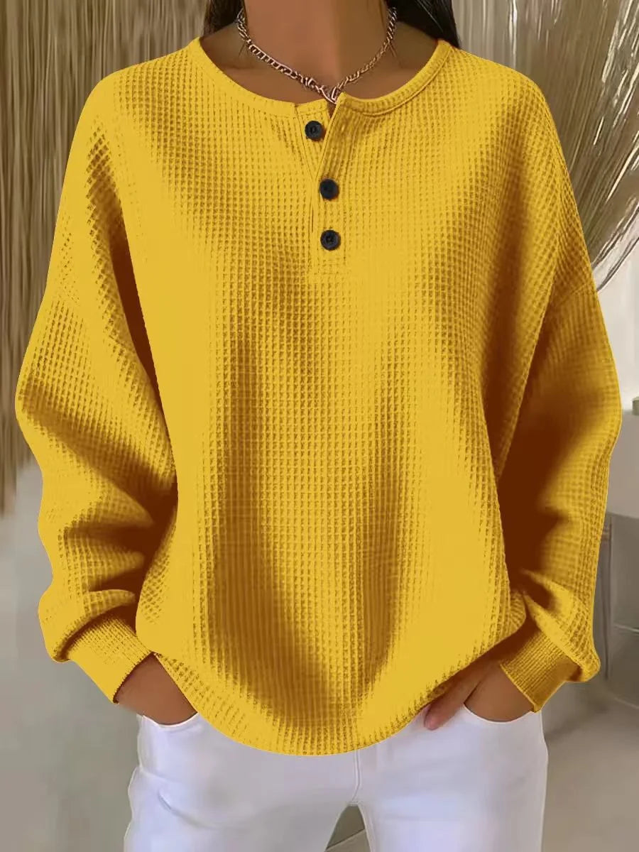 Detail shot of waffle knit texture and henley neckline on women's jumper