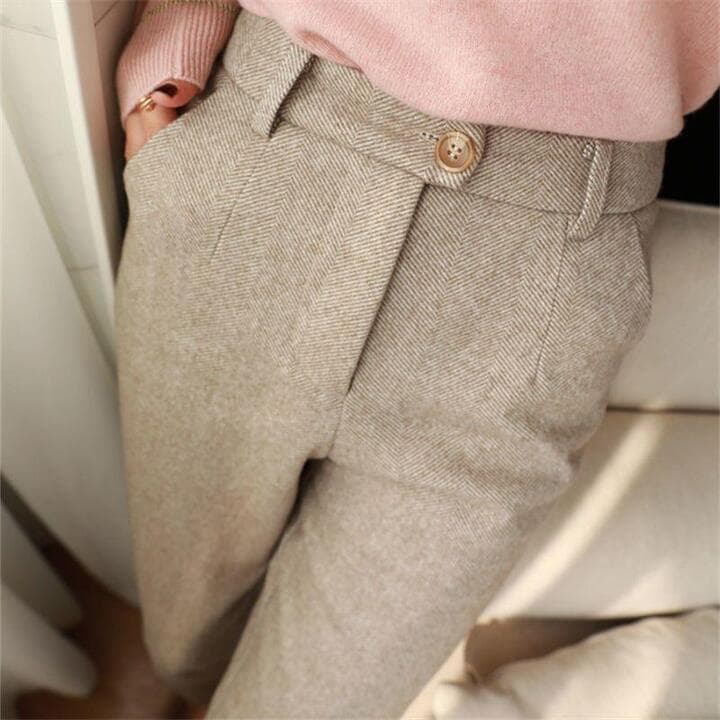 Close-up of herringbone weave pattern on men's pleated trousers showing textured fabric detail
