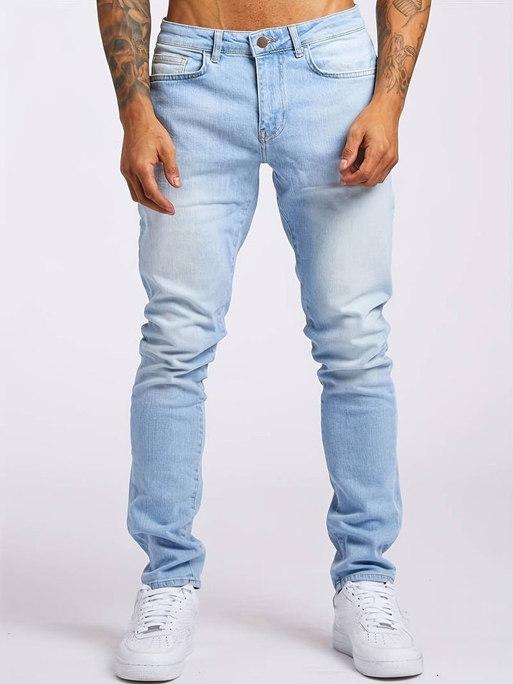 Men's faded wash jeans styled with white trainers for casual wear