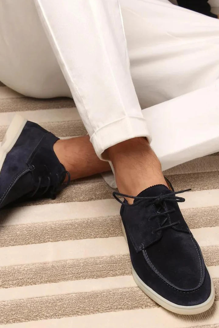 Side view of men's navy suede loafers showing lace-up detail and classic silhouette with modern twist