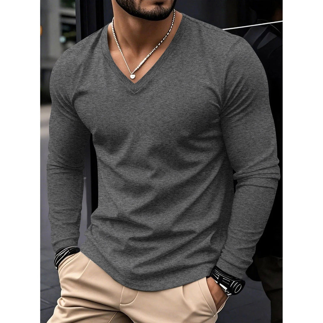 Man wearing charcoal grey men's v-neck long sleeve t-shirt with beige trousers in casual setting