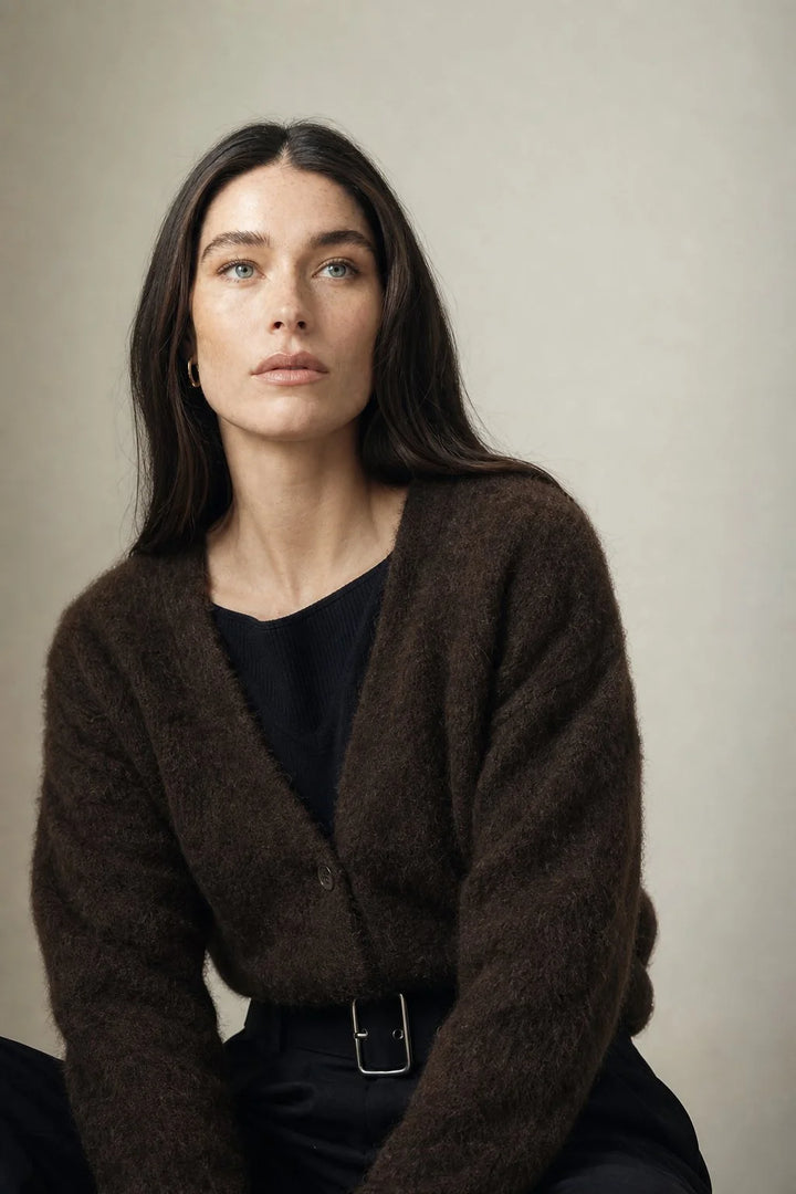 Woman styling cashmere cardigan for cosy winter layering with neutral tones