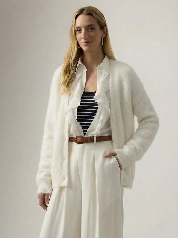Woman wearing cream cashmere cardigan with V-neckline in minimalist setting