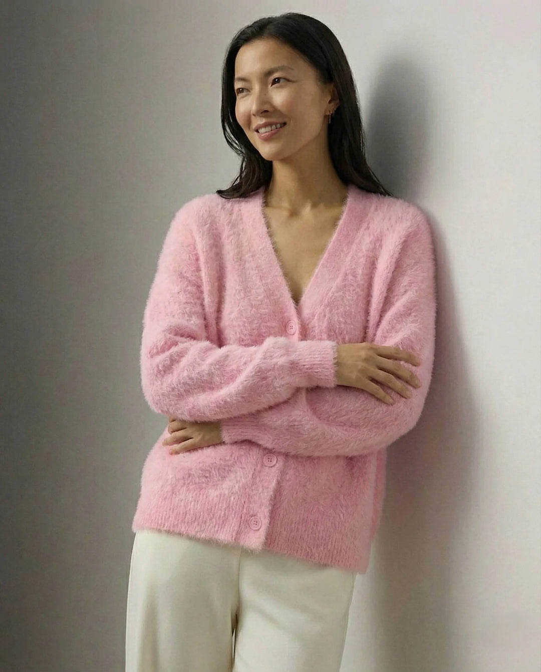 Woman wearing cashmere cardigan in cosy interior with soft lighting