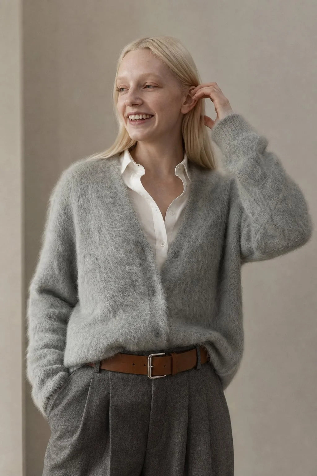 Side profile of oversized cashmere cardigan with dropped shoulders and ribbed cuffs on model