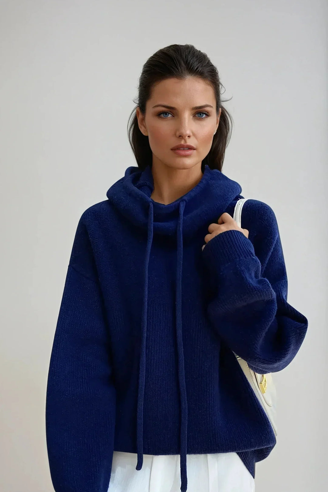 Close-up view of textured knit hooded jumper showing ribbed cuffs and structured fabric finish