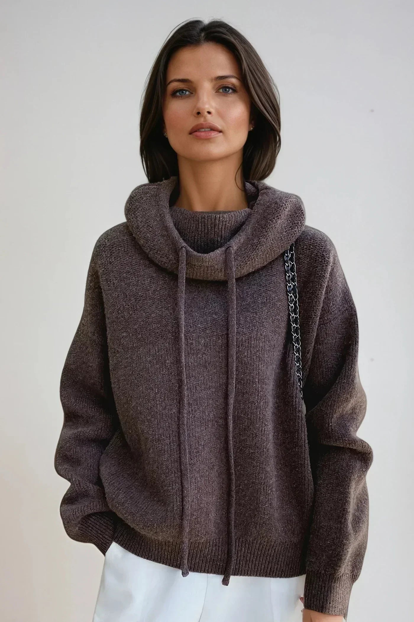 Side angle of oversized knit hoodie with drop shoulders and adjustable drawstring detail