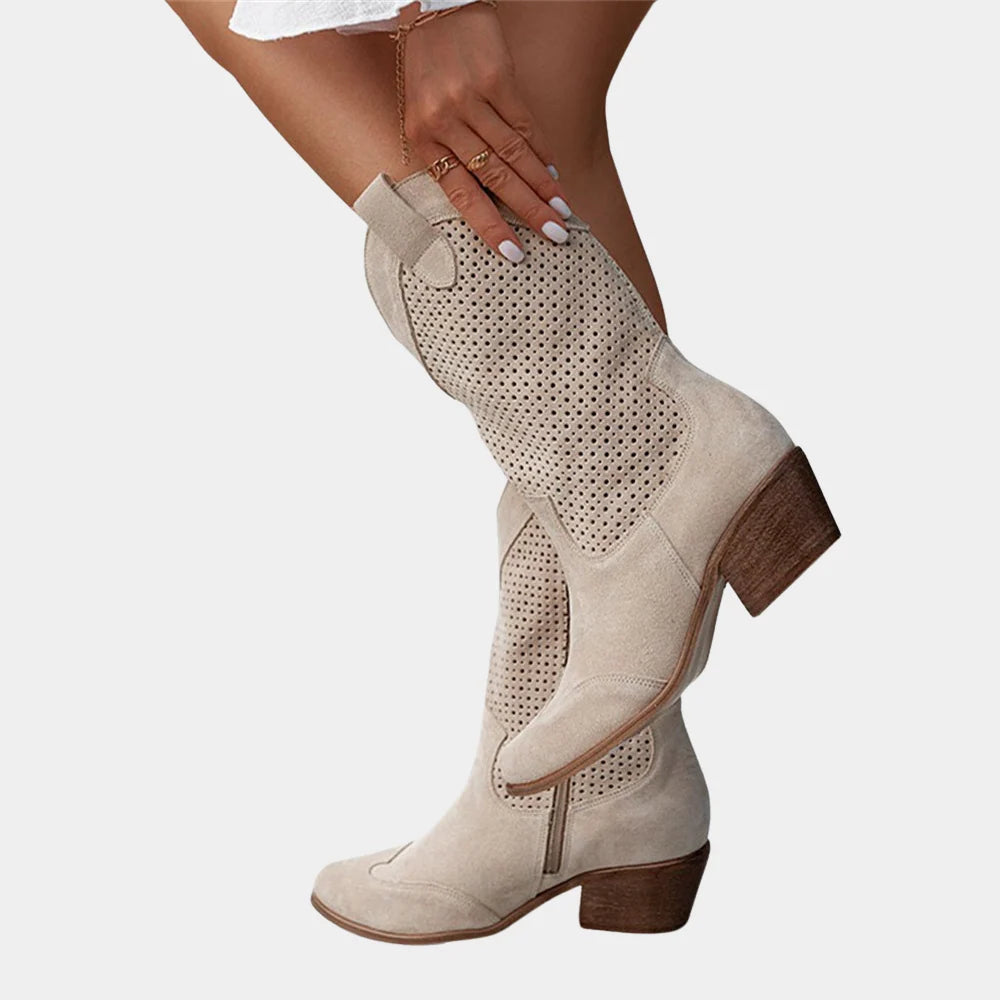 Side view of beige cowboy boots showing block heel construction and pull-on tab at back