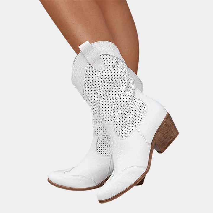 Women's mid-calf boots with all-over perforations styled with white dress and brown watch