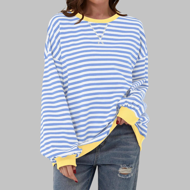 Striped crew neck jumper styled with jeans showing relaxed fit and long sleeves