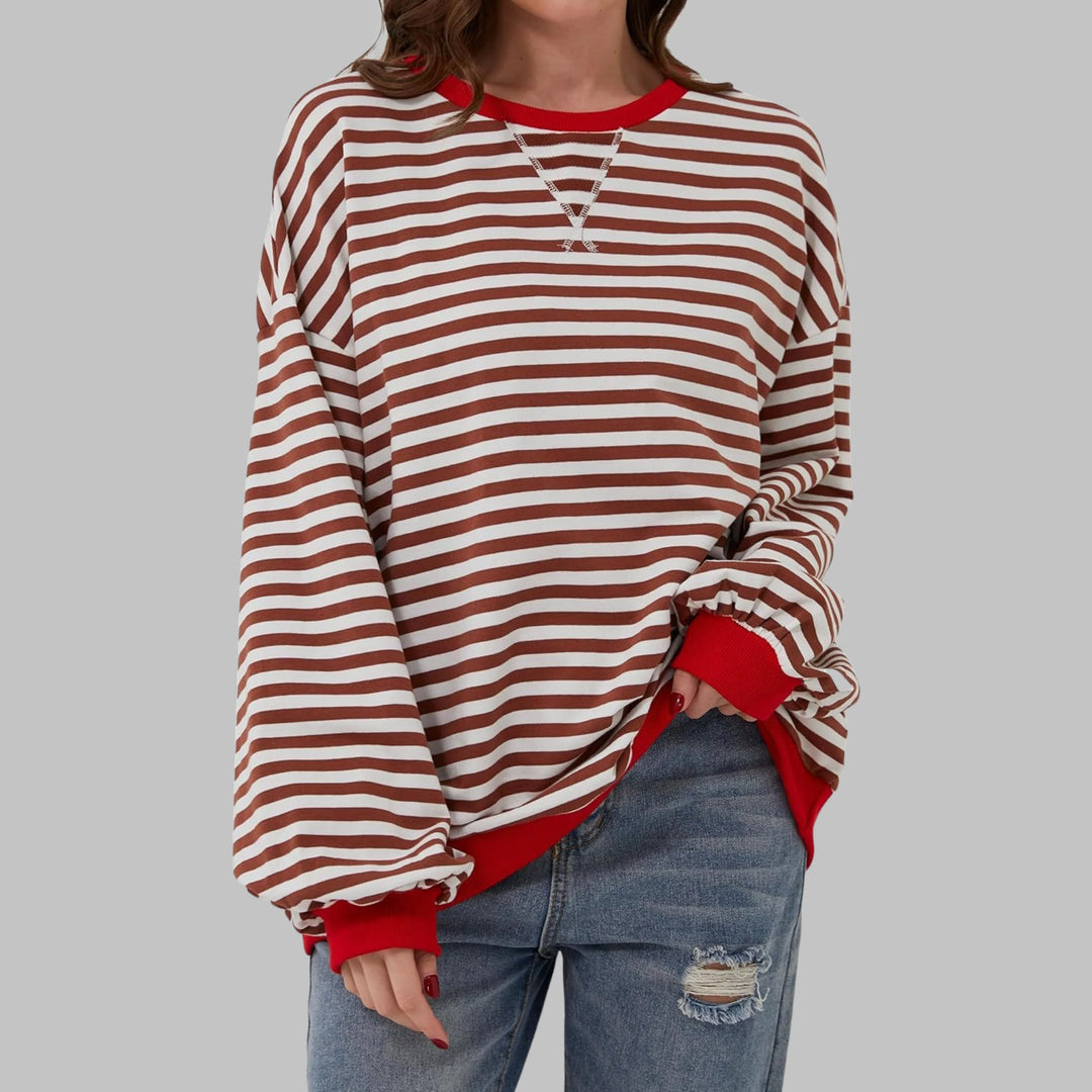 Women's striped jumper in green and navy worn casually with distressed denim jeans